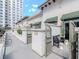 Exterior view of a charming patio entrance and courtyard with manicured green plants, a city building in the background, and a bench at 450 Knights Run Ave # 414, Tampa, FL 33602