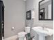 Powder room with gray walls, pedestal sink, and decorative mirror in modern home at 450 Knights Run Ave # 414, Tampa, FL 33602