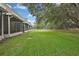 The meticulously manicured backyard features lush green grass, creating a serene outdoor haven at 4921 Barnstead Dr, Riverview, FL 33578