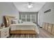 Bright bedroom with a large bed, window, and wood-look flooring at 4921 Barnstead Dr, Riverview, FL 33578