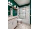 Bathroom featuring green walls, vanity, toilet, and a shower with glass sliding doors at 502 36Th W St, Palmetto, FL 34221