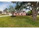 Lovely pink home featuring a lush front yard and mature trees offering shade, set in a serene neighborhood at 502 36Th W St, Palmetto, FL 34221