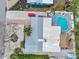 Aerial view of home featuring a uniquely shaped pool, tiki hut, brick patio, and lush tropical landscaping at 504 69Th St, Holmes Beach, FL 34217