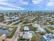High-angle view displays waterfront community with lush greenery, private pools, and boat docks under a cloudy sky at 504 69Th St, Holmes Beach, FL 34217