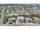 High-angle view of a neighborhood with palm-lined streets, homes, and private pools under a cloudy sky at 504 69Th St, Holmes Beach, FL 34217