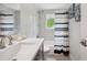 Bright bathroom features a white vanity with gray cabinets, shower/tub combo with stylish tile, and nautical decor at 504 69Th St, Holmes Beach, FL 34217