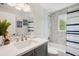 Bright bathroom features a white vanity with gray cabinets, shower/tub combo with stylish tile, and nautical decor at 504 69Th St, Holmes Beach, FL 34217