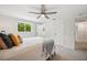 Bright bedroom features neutral colors, a modern ceiling fan, large windows, and closet and en suite bathroom access at 504 69Th St, Holmes Beach, FL 34217