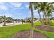 Canal-front home featuring lush green grass and well-maintained landscaping with tropical plants at 504 69Th St, Holmes Beach, FL 34217