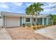 Charming home featuring a brick driveway, a one car garage and meticulous landscaping with tropical plants at 504 69Th St, Holmes Beach, FL 34217