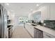 A bright kitchen with white cabinetry, modern appliances, and an open layout to the living area at 504 69Th St, Holmes Beach, FL 34217