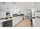 Modern kitchen with long countertops, white cabinetry, and stainless steel appliances at 504 69Th St, Holmes Beach, FL 34217