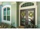 Elegant front doors with decorative wreaths, sidelight window, and well-maintained landscaping at 5269 Karlsburg Pl, Palm Harbor, FL 34685