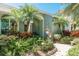 Lush landscaping highlights this home's entrance with a brick walkway and hanging flower pots at 5269 Karlsburg Pl, Palm Harbor, FL 34685