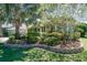 Beautiful landscaping surrounds this house, with an American flag displayed at 5269 Karlsburg Pl, Palm Harbor, FL 34685