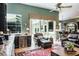 Bright living room featuring a cozy armchair, bar area, and sliding glass doors at 5269 Karlsburg Pl, Palm Harbor, FL 34685