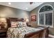 Main bedroom featuring a large window, wooden floors, and warm, stylish decor at 5269 Karlsburg Pl, Palm Harbor, FL 34685