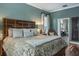 Well-lit main bedroom featuring a unique headboard and ensuite bathroom access at 5269 Karlsburg Pl, Palm Harbor, FL 34685