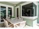 Outdoor patio with a dining table, modern wicker chairs, a wall-mounted speaker, and a large window at 5269 Karlsburg Pl, Palm Harbor, FL 34685