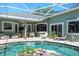Enclosed pool with transparent decorative globes, waterfall feature, and patio furniture near the pool at 5269 Karlsburg Pl, Palm Harbor, FL 34685
