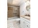 Well-maintained bathroom with a tiled shower, glass door, granite countertop, and white cabinets at 5575 Gulf Blvd # 421, St Pete Beach, FL 33706