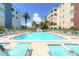Inviting pool area surrounded by lounge chairs, palm trees, and well-maintained buildings at 5575 Gulf Blvd # 421, St Pete Beach, FL 33706