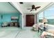 Bright sun room with large windows, ceiling fan, comfortable seating, and a view of the surrounding buildings at 5575 Gulf Blvd # 421, St Pete Beach, FL 33706