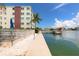 Scenic waterfront view featuring a community dock, lush landscaping, and beautiful blue skies at 5575 Gulf Blvd # 421, St Pete Beach, FL 33706