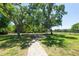Spacious backyard featuring mature trees and a brick pathway, creating a serene outdoor retreat at 5807 Thoreau Pl, Lithia, FL 33547
