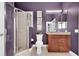 Modern bathroom featuring shower, toilet, vanity, art and purple walls at 5807 Thoreau Pl, Lithia, FL 33547