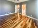 Spacious bedroom features hardwood floors, gray walls, and doors leading to bathroom and other rooms at 5807 Thoreau Pl, Lithia, FL 33547