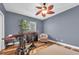 Bedroom with hardwood floors, chair, ceiling fan, natural light and a craftsman style industrial desk and rolling stool at 5807 Thoreau Pl, Lithia, FL 33547