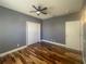 Spacious bedroom features hardwood floors, closet, ceiling fan, light gray walls, and white doors at 5807 Thoreau Pl, Lithia, FL 33547
