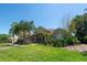 Beautiful single-story home featuring a well-manicured lawn, lush landscaping and a tan stucco exterior at 5807 Thoreau Pl, Lithia, FL 33547