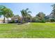 Beautiful single-story home with lush green lawn, mature landscaping, and a large front yard under blue skies at 5807 Thoreau Pl, Lithia, FL 33547