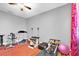 Bright gym features fitness equipment, colorful curtains, light gray walls and a ceiling fan at 5807 Thoreau Pl, Lithia, FL 33547