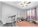 Bright gym features fitness equipment, colorful curtains, light gray walls and a ceiling fan at 5807 Thoreau Pl, Lithia, FL 33547