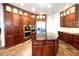 Gourmet kitchen featuring rich wood cabinetry, an island, and stainless steel appliances at 5807 Thoreau Pl, Lithia, FL 33547