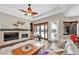 A living room with a decorative fireplace, and plush seating that leads to the outdoor pool area through french doors at 5807 Thoreau Pl, Lithia, FL 33547