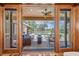 Through the French doors to an inviting outdoor pool and patio area with comfortable seating and green surroundings at 5807 Thoreau Pl, Lithia, FL 33547
