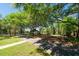 Community playground with mature trees providing shade and red play equipment with benches nearby at 5807 Thoreau Pl, Lithia, FL 33547