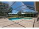 Enclosed in-ground pool with tiled patio and screened enclosure that is surrounded by beautiful green lawn at 5807 Thoreau Pl, Lithia, FL 33547