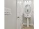 Stylish powder room featuring a pedestal sink, oval mirror, and modern lighting fixtures at 5833 Grand Sonata Ave, Lutz, FL 33558