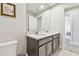Bathroom featuring a dual vanity with modern faucets and lighting fixtures, next to a toilet at 5833 Grand Sonata Ave, Lutz, FL 33558