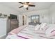 Comfortable bedroom features ceiling fan, dresser with television, and coordinating decor at 5833 Grand Sonata Ave, Lutz, FL 33558