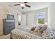 Cozy bedroom with ceiling fan, window view, and stylish dresser and furnishings at 5833 Grand Sonata Ave, Lutz, FL 33558