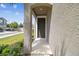 Inviting front entryway featuring a modern door, covered porch, and landscaped surroundings at 5833 Grand Sonata Ave, Lutz, FL 33558
