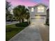Two story home with a two car garage, palm tree, and beautiful landscaping at 5833 Grand Sonata Ave, Lutz, FL 33558