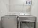 Laundry room showcasing modern, front-load washer and dryer with wire shelving above at 5833 Grand Sonata Ave, Lutz, FL 33558