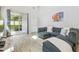 Comfortable living room with a modern sofa, tiled floors, and sliding glass doors to the lanai at 5833 Grand Sonata Ave, Lutz, FL 33558